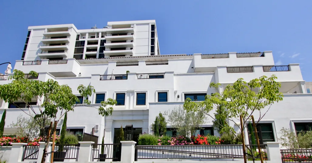 A beautiful sky high well construct building which have elegant colour and shiny bright glass windows. Lots of green trees enhance its beauty. A sunny bright day give it an amazing look.