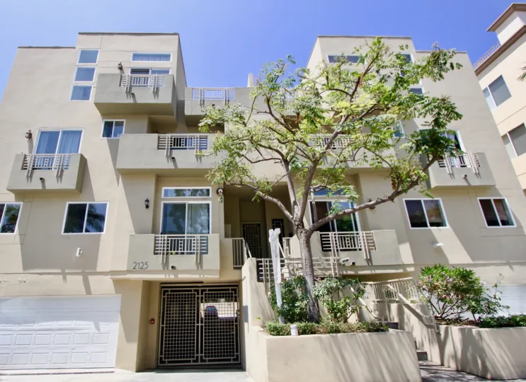 A sunny day in the Bentley Crest with beautiful apartment and a big tree infrond of the apartment.