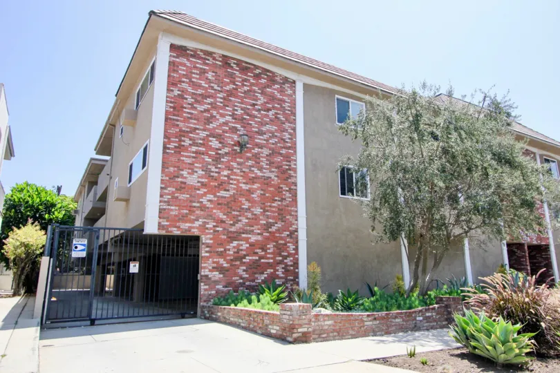 The Bentley Manor building is looking wonderful the glass windows, trees and black color gate in front of the apartment
