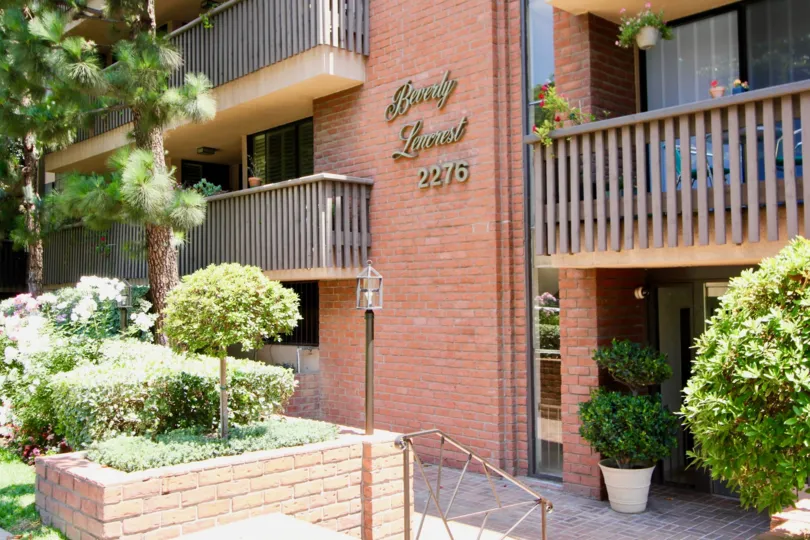 A sunny day in the Beverly Lencrest with beautiful apartment and a big tree infrond of the apartment.