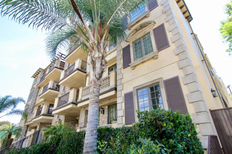 A sunny day in the Borgata Residence with beautiful house and a big tree infrond of the house.