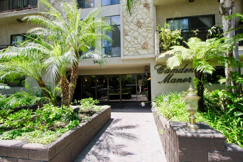 A sunny day in Camden Manor CA, showing the fronatge of a building and palm trees