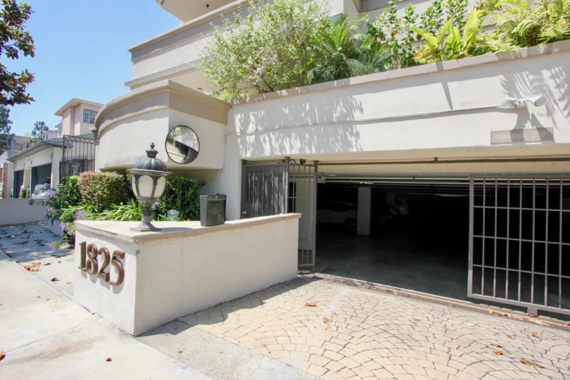 A sunny day outside Century Geln Townhomes with an open parking garage and 1825 listed on a block outside the building