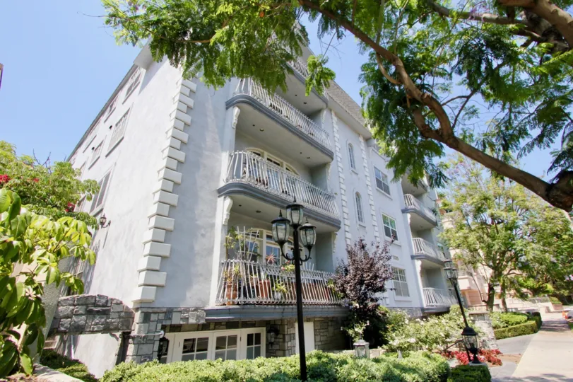 A sunny day in the Chateau Glen with beautiful apartment and a big tree infrond of the apartment.