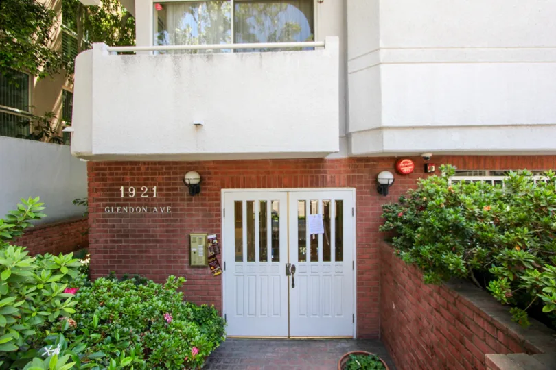 A sunny day in the Glendon House Westwood with beautiful apartment and a big tree infrond of the apartment.