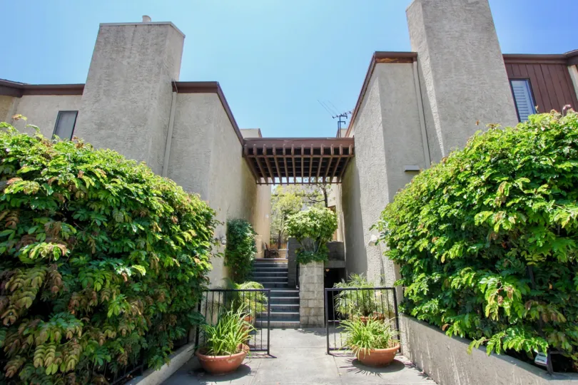 A beautiful day in the Greenfield Townhomes with a small gate and pots.