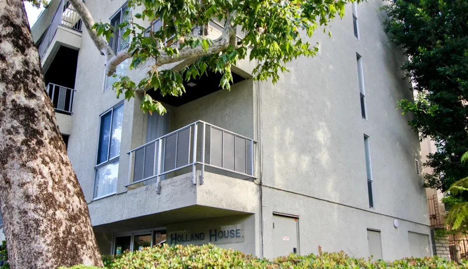 THE BUILDING IS HOLLAND HOUSE IT IS IN FRONT OF TREES IS A WONDERFUL VIEW