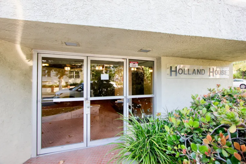 THE BUILDING NAME IS HOLLAND HOUSE IS VERY BIG SIZE DOAR AND IN FRONT OF TREES