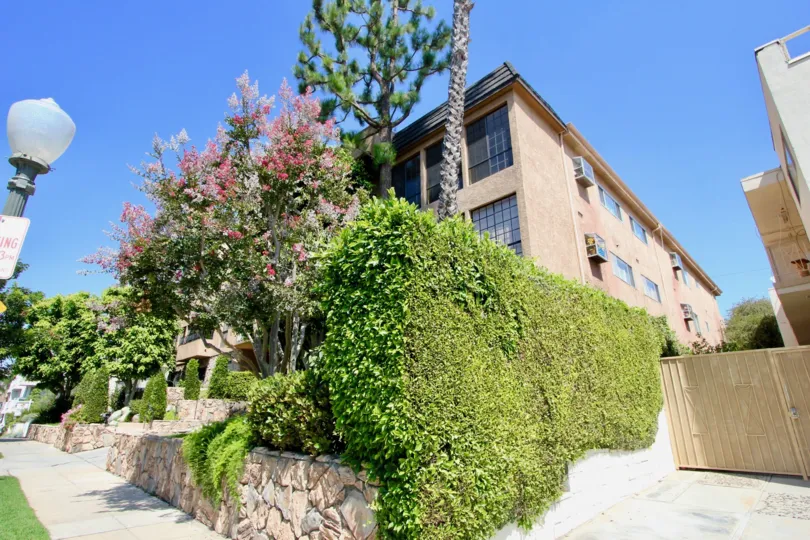 A great day in the Kinnard Villas with a big building and plants.