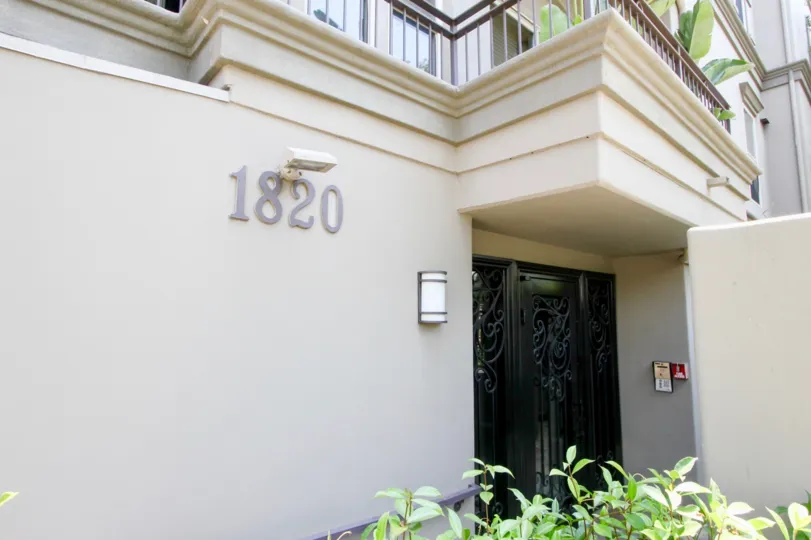 A black dooe to the entrance of the La Benecia community with the address 1820 on the wall