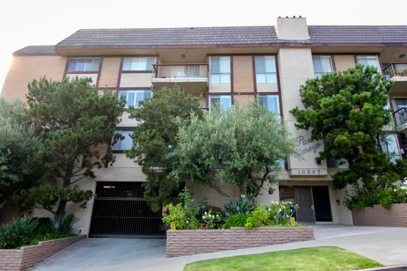 Classy view and then entrance to Park Almayo's beautiful brown walls and greenery, Westwood, California
