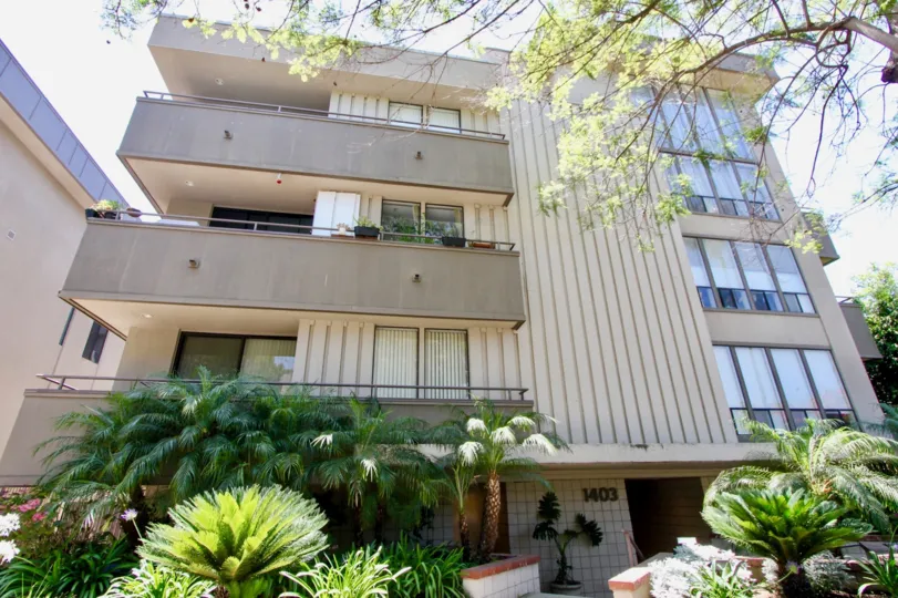 A tall grey building in the Parkview North neighborhood with three balconies and green plants