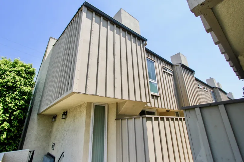 Back exterior of a stucco home in Parnell Terrace community in Westwood, California on a sunny day.