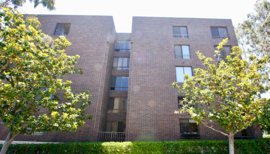 A lovely day at Rancho Glen East, a bricked residential building which has a very secure feel and trees.