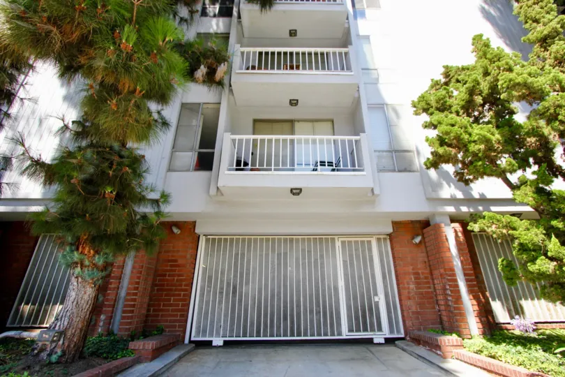 An apartment building in Westwood, CA with two large balconies and a garage under the building