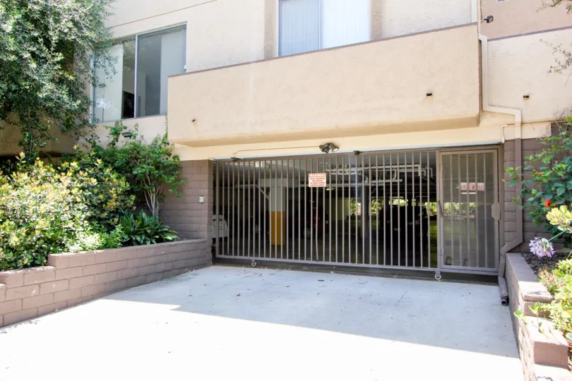 A gated parking garage with shrubbery at The Westwoodian.