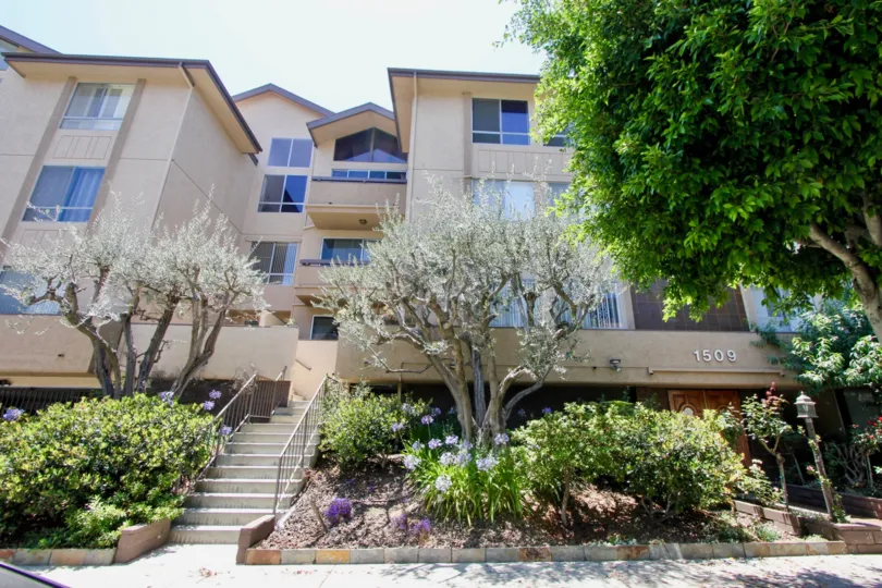 A lovely view of the Westwoodian, a residential building with a southwest feel and a garden with a wide variety of plant life.