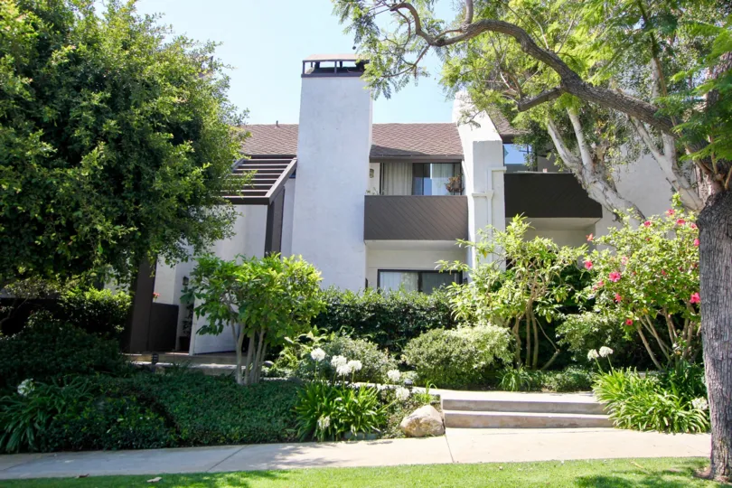 A sunny day the Village Townhouse is very beautiful in front of the house beautiful plants and flowers are present