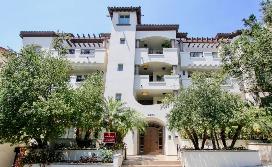 An apartment building in the Westwood Fairburn community with large balconies and lush trees