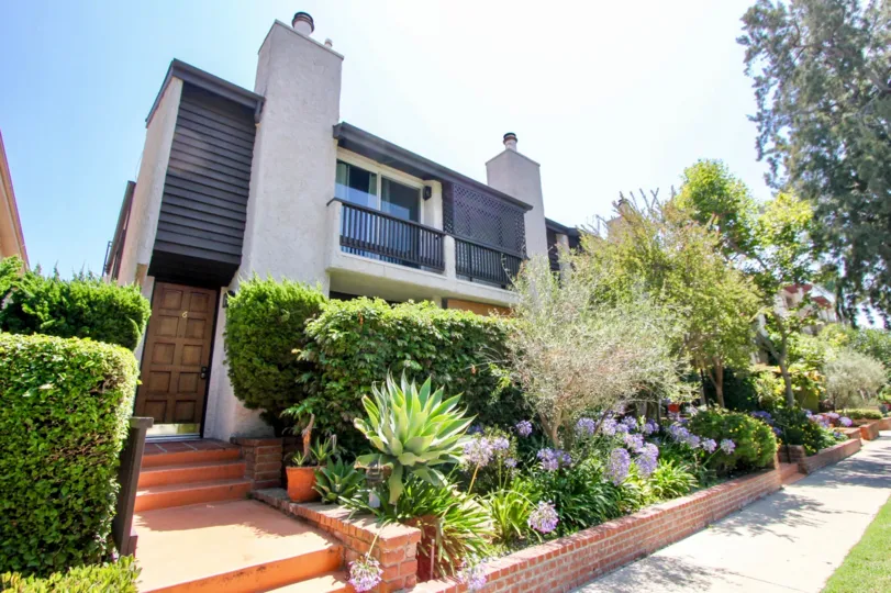 Sidewalk and garden in front of Westwood Townhouses on a sunny day.
