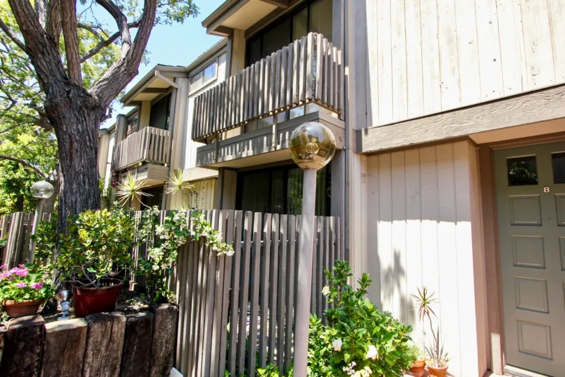 View from street level of the Woodvale Village building in Westwood, CA, showing apartment balconies and plants.