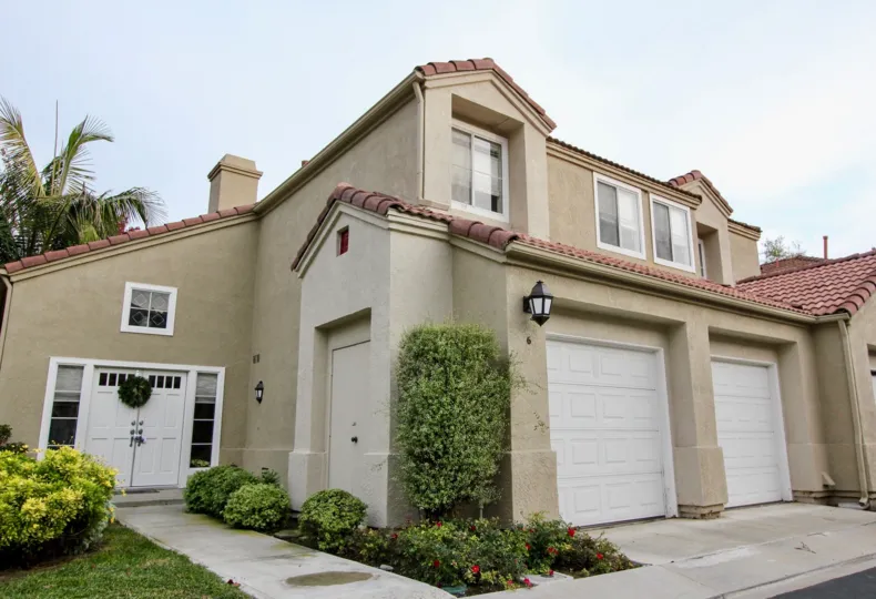 End unit attached home with doulbe car garage with individual doors and stucco siding at California Renaissance