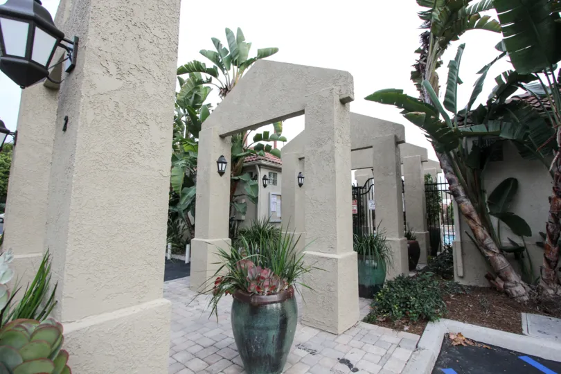 Path to the gate of Apartment in California Renaissance has light lamp and flower pots