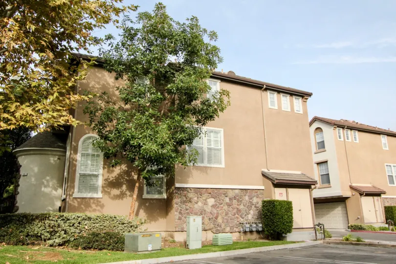 A stone accent wall climbs the side of a Camden Park building.