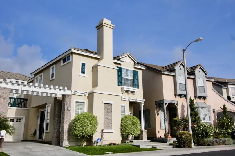 Townhomes with landscaping and clouds in sky above.