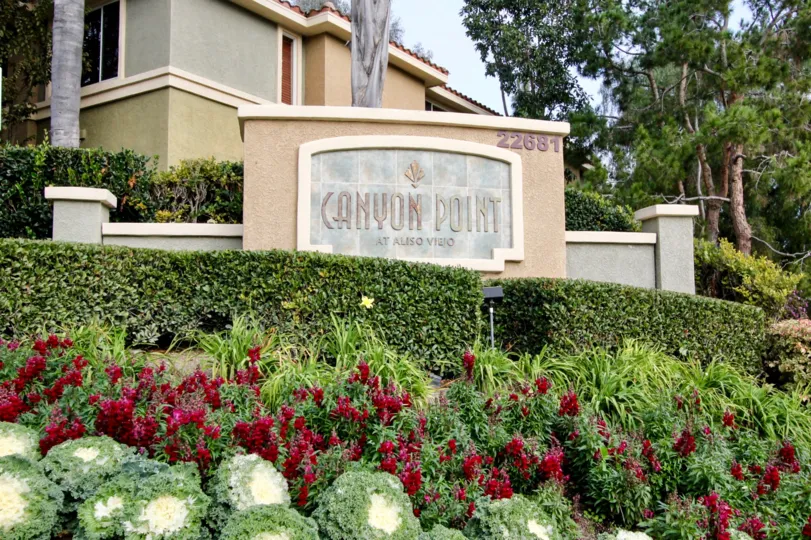 Well kept hedges and vibrant foliage surround Canyon Point's welcome sign.