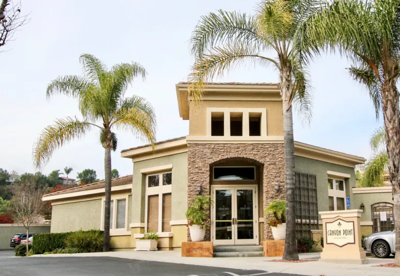 A small business establishment with palm trees and a sign for Canyon Point.