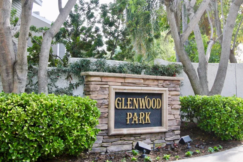 A SUNNY DAY IN THE GLENWOOD PARK WITH THE GLENWOOD PARK BOARD, PLANTS, TREES, LIGHTS