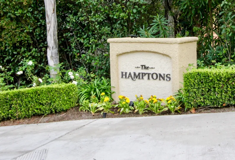 A bright day in the Hamptons with a signage and wall.