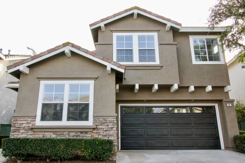 A two story home with a large black garage sits in the community of Harvest in Aliso Viejo, California.