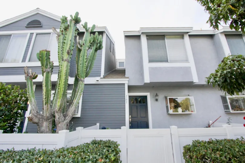 A sweet ash color building in the Morningside Terrace with some shrubs and plants.
