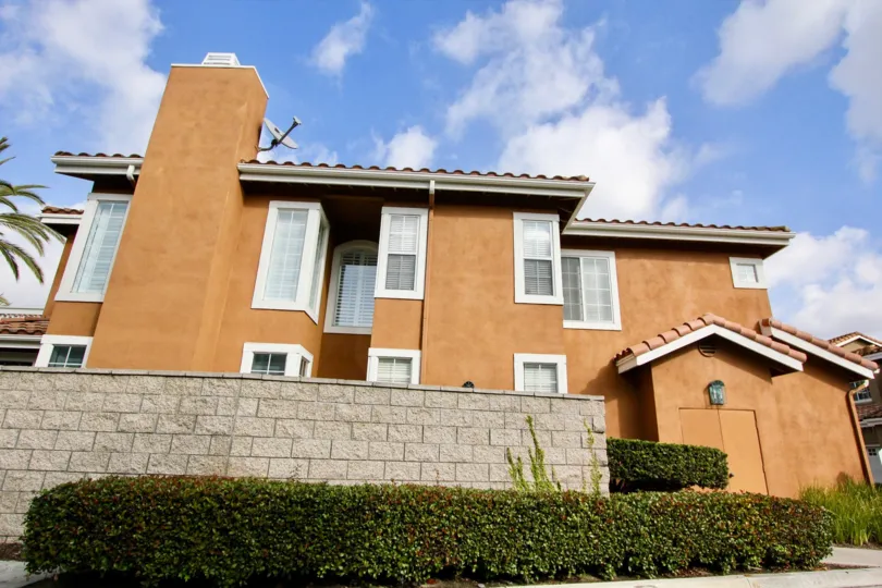 A sunny day in the Provence D'Aliso a big sweet home with some shrubs and a compound wall also.