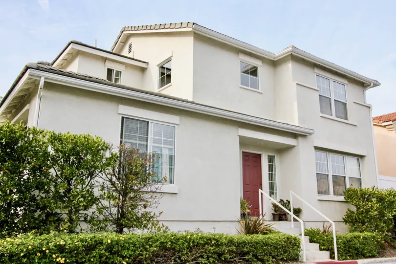 Corner lot house with main entrance on the side with double car garage and stucco siding in San Simeon