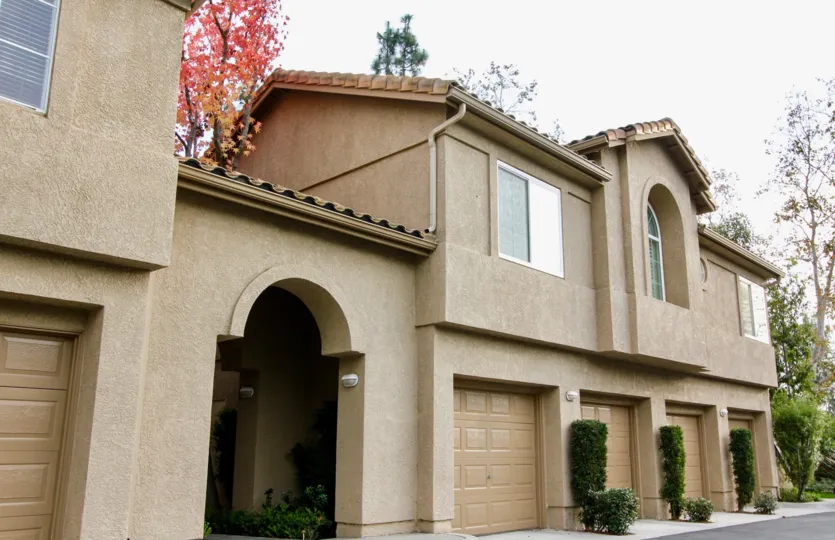Condominium with four car garage and metal roof with landscaping