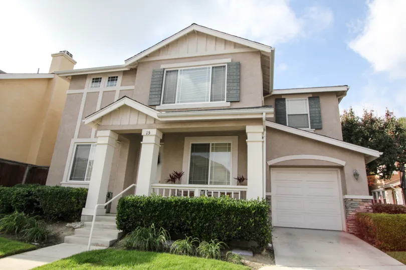 2 Storey single car garage house with decorative shutters, stucco siding and large entryway pillars in Soleil