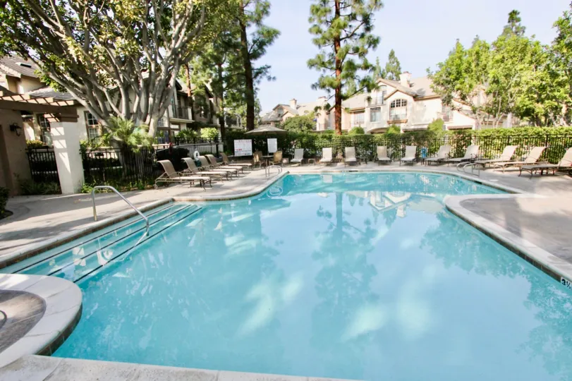 Shady pool surrounded by trees in the St. Tropez Community in Aliso Viejo, CA.