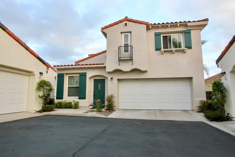 The hunter green front door and shutters accentuate this The Colony home's unique Spanish style.