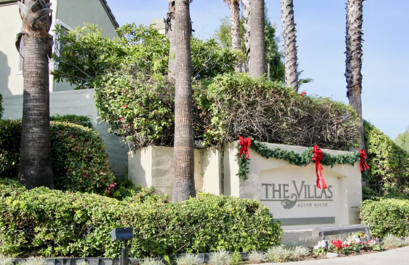 The Villas's sign is surrounded by palm trees and adorned with a festive Christmas garland.