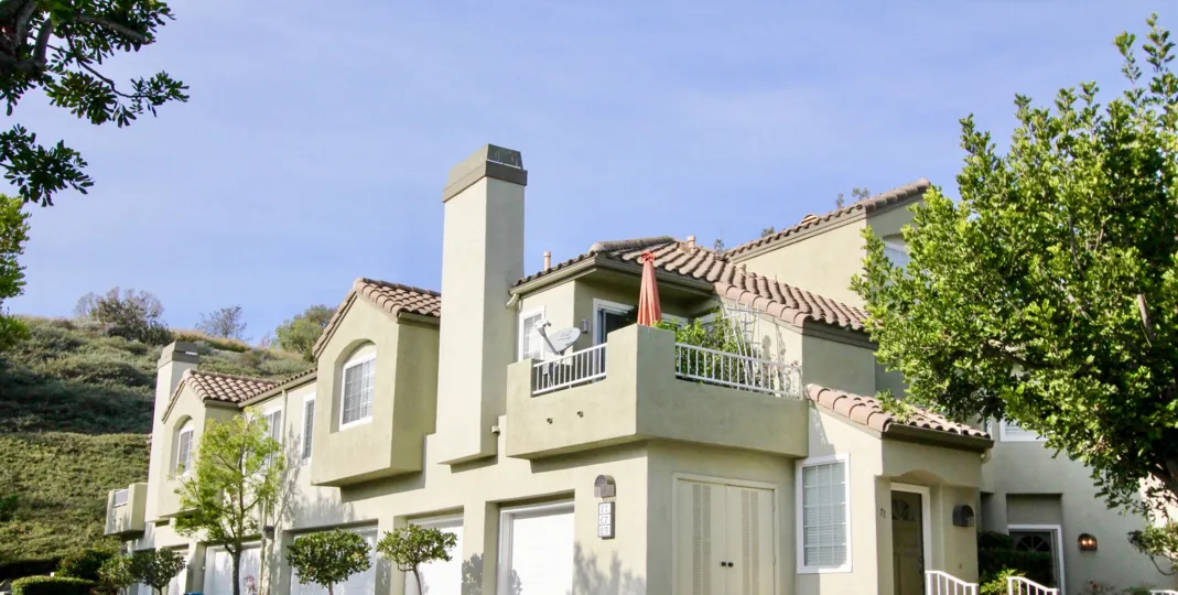A pale green building offers a unique corner balcony and a great view of the The Villas landscape.