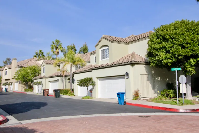 A sunny day in the The Villas with some buildings and dust bin.