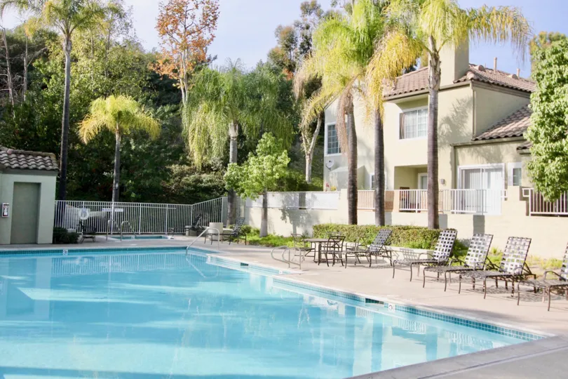 Apartments overlook the crystal blue The Villas pool, with lounge chairs ready for relaxing nearby.