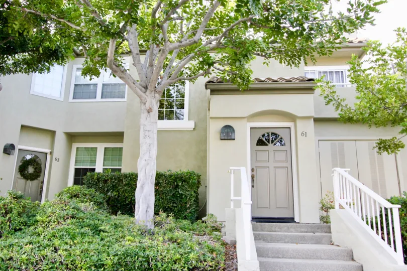 A beautiful wight color house in the The Villas with some shrubs, plants and trees also.