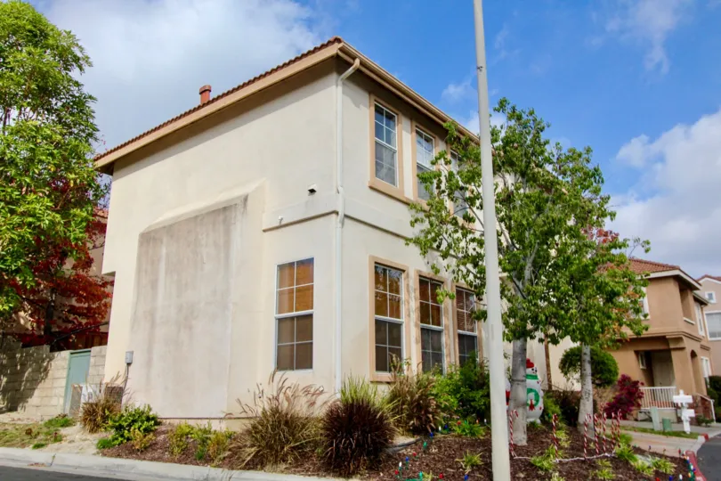 a warm day in the tiburon witha house that has a doll in the front garden and a lamp post