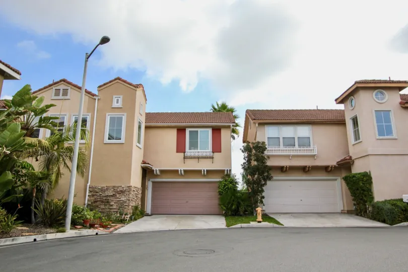 Two homes stand side by side under a cloudy sky in the Tiburon neighborhood.