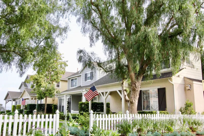A house in the Twelve Picket Lane community in Aliso Viejo, CA surrounded by a picket fence and large trees