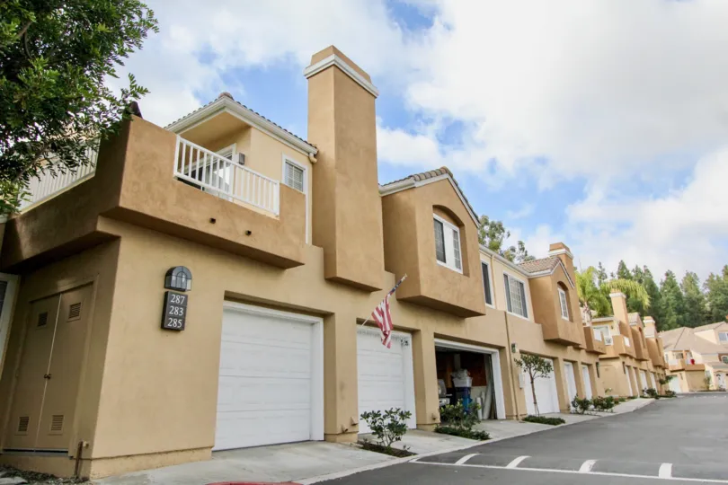 Apartments with garages and a cloudy sky in the Villas South Community in Aliso Viejo, CA.